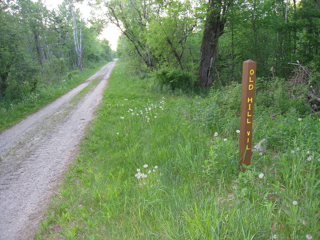 Old Hill Village - South End 395.jpg - In February 1937, residents of Hill Village NH learned that their village, near the Pemigewasset River, was to become a flood control reservoir for the Franklin Falls dam project. To accommodate the construction of the Franklin Falls Dam, the village of Hill NH was to be relocated. By January of 1940, the citizens of Hill NH formed an association, purchased land, and began planning a new model village with the help of the NH State Planning and Development Commission. Construction started in 1940, and by June of 1941 the new town hall and school were completed, along with the streets, water system, and 30 houses. The 1941 town meeting was called to order in the old town hall, recessed, and reconvened in the new village.
